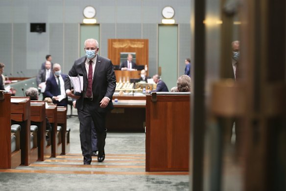 Prime Minister Scott Morrison wearing a mask departs the chamber at the end of Question Time at Parliament House in Canberra.