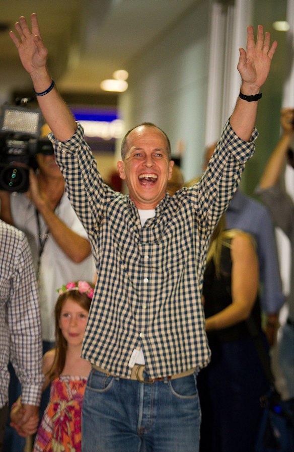 Al-Jazeera journalist Peter Greste celebrates upon his arrival at Brisbane's international airport in the early hours of Thursday February 5, 2015