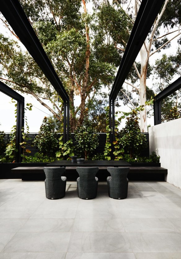 Landscape designer Jack Merlo’s entertaining area is visually connected to the home by steel beams that will eventually be covered with climbing ivy.