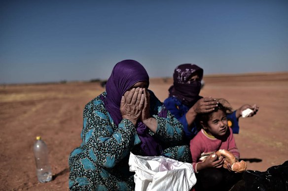 Refugees from the Syrian town of Ain al-Arab, known as Kobane by the Kurds, react after crossing the Turkish border with Syria near the city of Sanliurfa on October 4, 2014. Photo by AFP