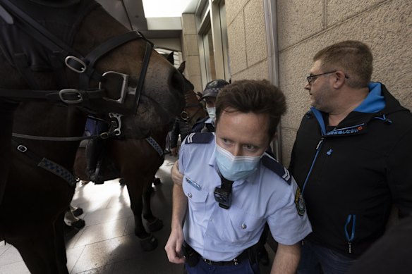 A Police Officer escapes a large mob during a large Anti-lockdown protest in Sydney 24 July, 2021.