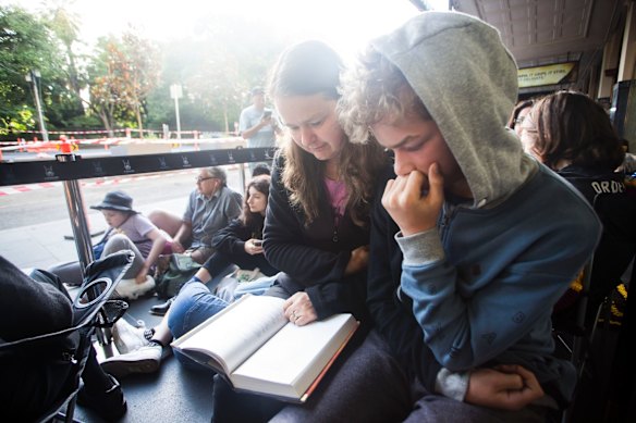 Michelle and her son Hamish read Harry Potter as they wait for tickets.