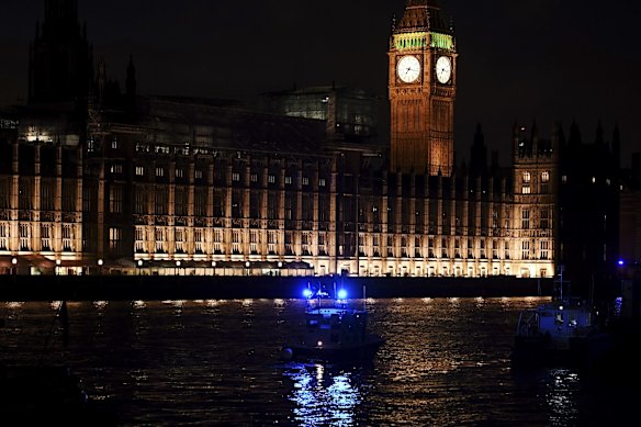 Police boats patrol outside the Houses of Parliament after a terrorist attack.