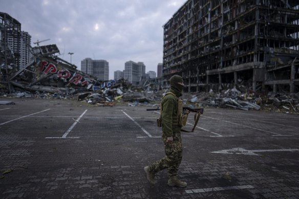 A soldier walks the amid the destruction caused after shelling of a shopping center on March 21st in Kyiv.