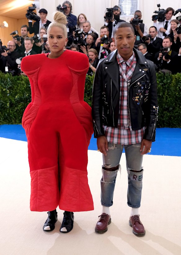 2017: Helen Lasichanh doing her best to look like a Cherry Ripe Pod snack, if they made such a thing, while husband Pharrell Williams is smiling because his wife's outfit doubles as a pillow should the night drag on.