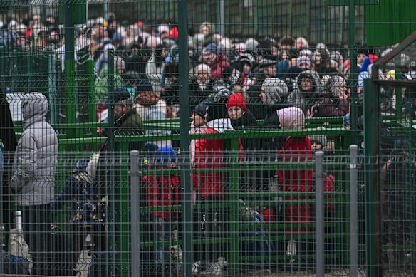 Refugees from Ukraine wait anxiously at passport control on the Polish-Ukrainian border.
