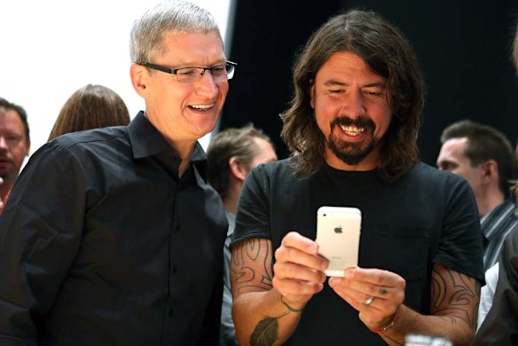 Apple CEO Tim Cook, left, and Dave Grohl of the Foo Fighters play with the iPhone 5.