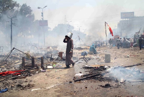 A supporter of Egypt's ousted president Mohamed Morsi walks through the debris following clashes with police in Cairo.