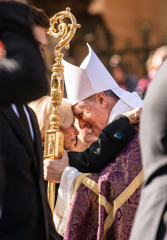 Anne Fulton embraces with a member of clergy after the State Funeral.