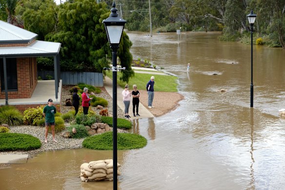 Residents watch the floodwaters near Campaspe Esplanade in Echuca West and help redirect the Campaspe River in an effort to save houses. 
