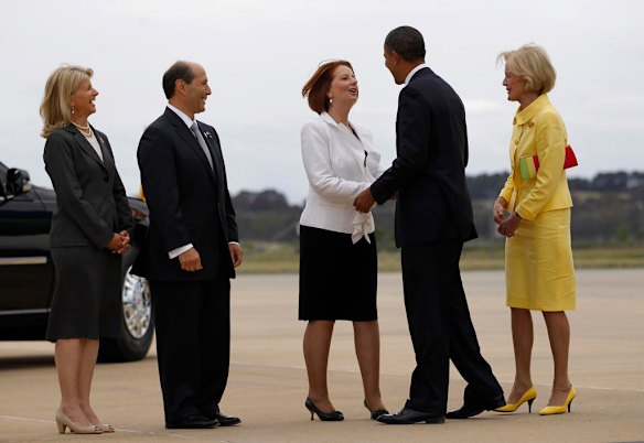 U.S. President Barack Obama is greeted by Australian Prime Minister Julia Gillard as Australia's Governor-General Quentin Bryce looks on in Canberra, Australia.