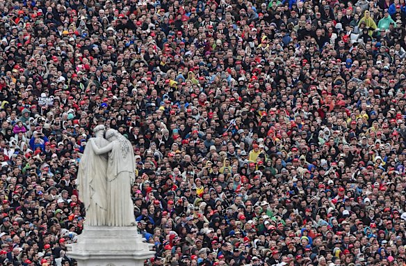 People listen during the inaugural address by President Donald Trump during the Inauguration on Capitol Hill in Washington.
