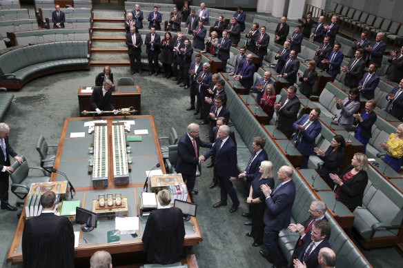 Prime Minister Scott Morrison is congratulated by MPs in the House of Representatives after the Senate passed his income tax cut package.