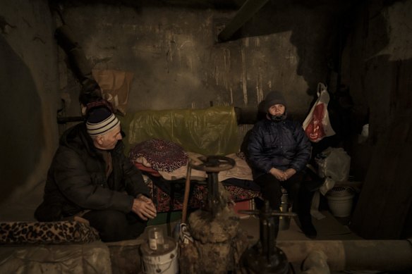 People take shelter inside the basement of a building during a Russian attack in Kharkiv.