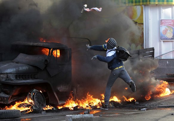 An anti-government protester throws a Molotov's cocktail during clashes with riot police outside Ukraine's parliament in Kiev, Ukraine, Tuesday, Feb. 18, 2014. Thousands of angry anti-government protesters clashed with police in a new eruption of violence following new maneuvering by Russia and the European Union to gain influence over this former Soviet republic.