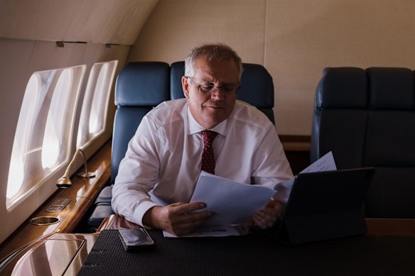 Time to revise: the Prime Minister on board a RAAF Boeing 737 BBJ flying from Sydney to Brisbane for several community events and policy announcements on December 20. 