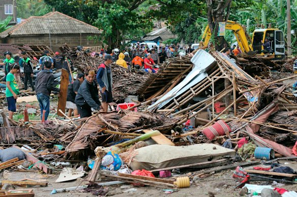 Residents look through rubble of flattened homes. 