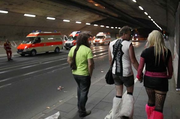 Revellers walk past ambulances on their way home following the Love Parade in Duisburg, Germany.