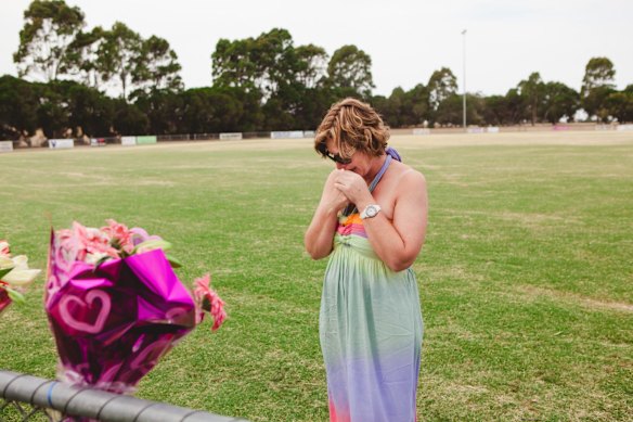 Luke Batty's mother, Rosie Batty, at Tyabb oval reading cards well wishers left following the death of her son in early 2014.