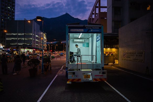 A person plays piano inside a Ming's Piano truck at a car park, in Hong Kong, China. In attempt to keep their business during the COVID-19 pandemic, Mings Piano, a music school with 12 teachers and about 200 students, has hired three trucks to deliver lessons at students' doorsteps.