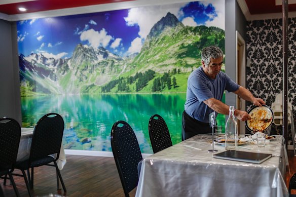 A mural of the Tenri Tagh mountains on the wall of Tarim restaurant's owner Akil Ruzeaji.