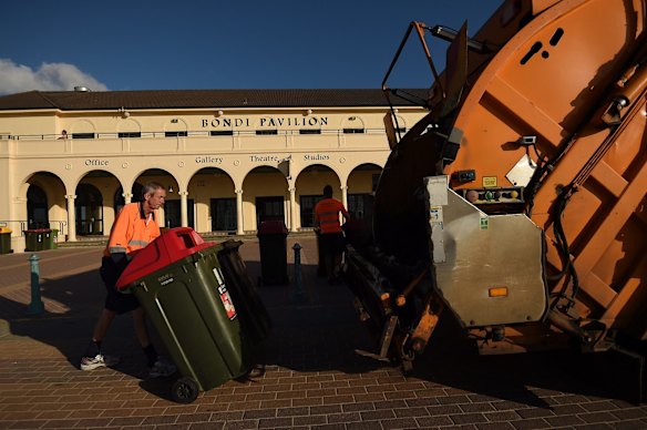 Men collect the rubbish at Bondi Beach.