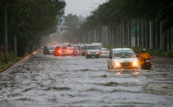 Motorists negotiate a flooded street following heavy rains and strong winds brought about by Typhoon Mangkhut.