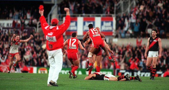 Sydney Swans congratulate Tony Lockett as he kicks a behind to beat Essendon to get into the 1996 Grand Final. Essendon Captain Gary O'Donnell lies on the SCG turf dejected.