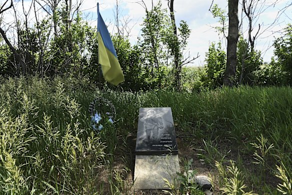 A Ukrainian flag and a memorial plaque mark the location of a fallen soldier at a position on the frontline near Krasnohorivka, several hundred meters away from the Russian-backed separatists position. The plaque reads 'To be a fighter means to live forever'. Donetsk Oblast, Ukraine. 