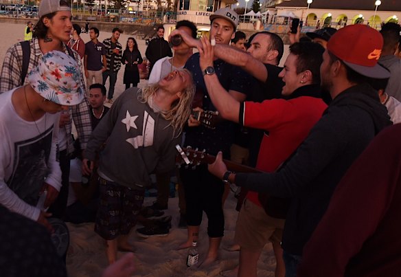 Backpackers celebrate the new year as the sun rises over Bondi Beach.