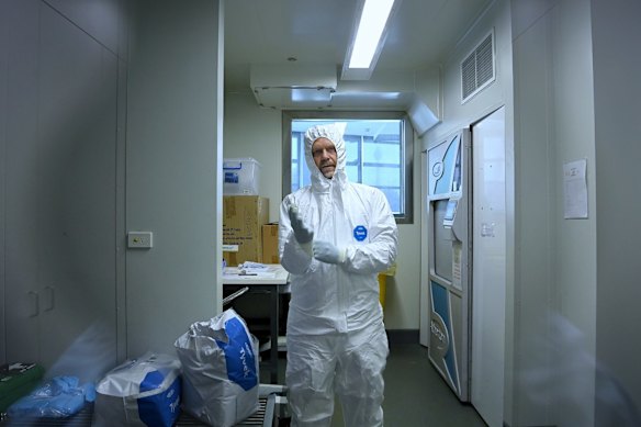 Associate Professor Stuart Turville, a virologist at the Kirby Institute working temporarily at St Vincent's Centre for Applied Medical Research, donning on PPE before analysing antibody reaction with the COVID-19 Omicron variant.