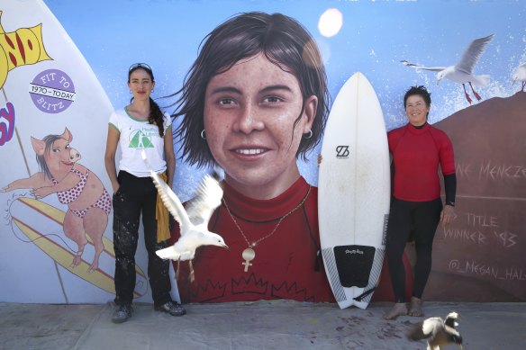 Artist Megan Hales (left) and her mural of 1993 World Surfing Champion Pauline Menczer (right) at Bondi Beach.