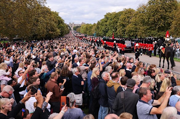 Mourners watch the State Hearse of Queen Elizabeth II as it drives along the Long Walk ahead of the Committal Service.