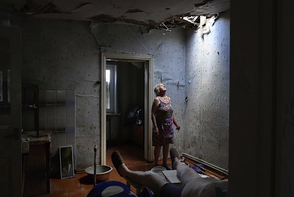 Zoya Shaposhnik 67yrs looks up at the hole ceiling in the room where her disabled husband was sitting when their home was damaged in an artillery strike the day before in Krasnohorivka, Ukraine. 