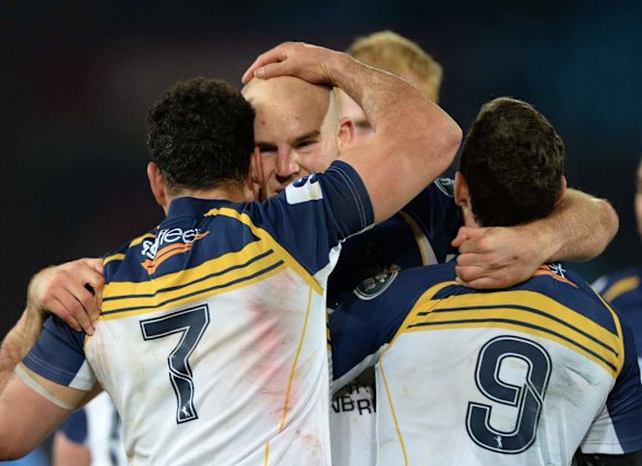 Stephen Moore of the Brumbies celebrates with George Smith and Nic White after the Brumbies' victory.