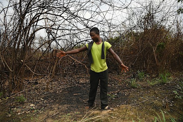 Former Kamuina Nsapu militia soldier Sylvain Ngandu, 23, gestures to where the sacred fire was lit in what was the Kamuina Nsapu bush camp where he stayed until their camp of over 100 militia were ambushed by government soldiers. Sylvain still has a wound on his foot caused by stepping on a grenade after being shot twice by government soldiers when he and other militia members were fleeing this bush camp during the surprise attack.