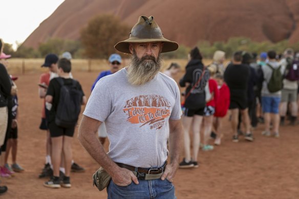 Yulara resident Rick Petersen who is a non-climbing advocate at the base of the climb as vistors to Uluru line up for the climb.