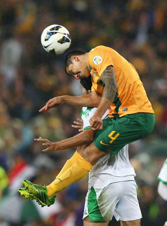 Tim Cahill of the Socceroos heads the ball.