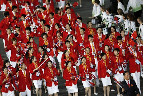 Members of China's contingent wave flags as they take part in the parade.