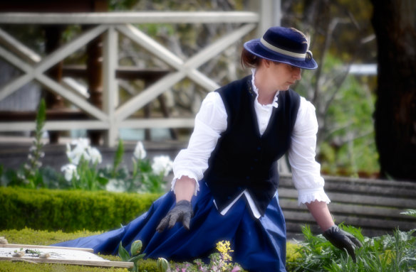Cherrie Neale, in gardening gloves and 1850s costume. 