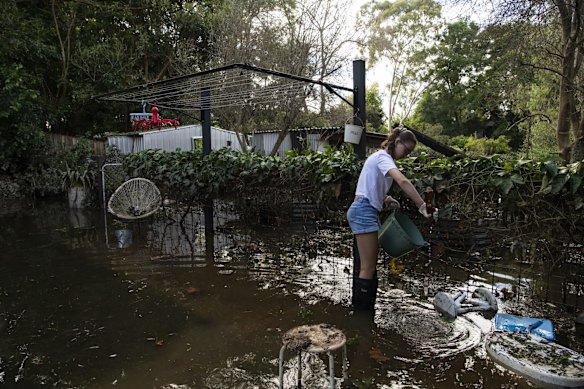 Teenager Ruby Bugeja helping clean her flooded home in Arnedell Street, Windsor. 