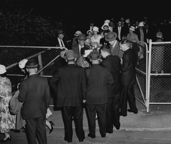 “Men stand shoulder-to-shoulder to shield members of the Exclusive Order of the Plymouth Brethren from photographers after their meeting at Ashfield last night. March 30, 1962”