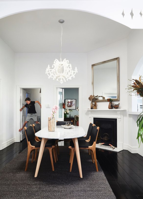 Luca scales a doorway in the dining room, which is the heart and hub of the home. The marble table is from Fenton &amp; Fenton, and the light from Surround Interiors.