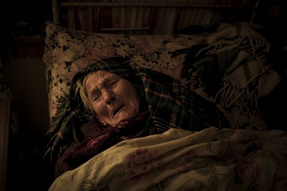 Motria Oleksiienko, 99, traumatised by the Russian occupation, lies in her bed in a room without heating in the village of Andriivka. Several buildings in the village were reduced to rubble and the surviving residents are without heat, electricity or cooking gas.