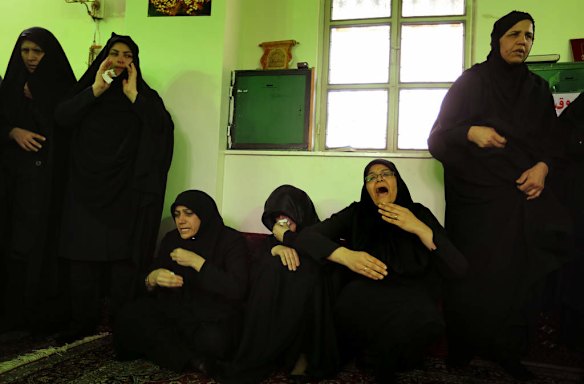 The sister of killed asylum seeker Reza Barati, Kowsar, 4th from left, is supported with her grief by her aunts and other family members during the memorial service.
