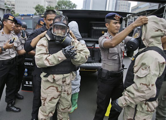 Members of the police bomb squad put on their protective gear prior to examining the site where an explosion went off in Jakarta, Indonesia Thursday, Jan. 14, 2016.  Attackers set off explosions at a Starbucks cafe in a bustling shopping area of downtown Jakarta and waged gun-battles with police Thursday, leaving bodies in the streets as office workers watched in terror from high-rise windows.