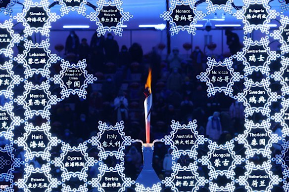 The names of all the competing countries are seen alongside the Olympic flame inside of the Beijing National Stadium ahead of the Winter Olympics closing ceremony on Sunday night.