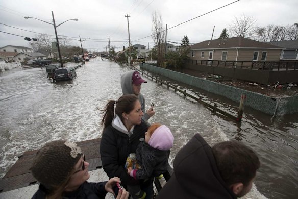 Residents look at flood waters left from Hurricane Sandy at the Breezy Point section of the Queens borough in New York
