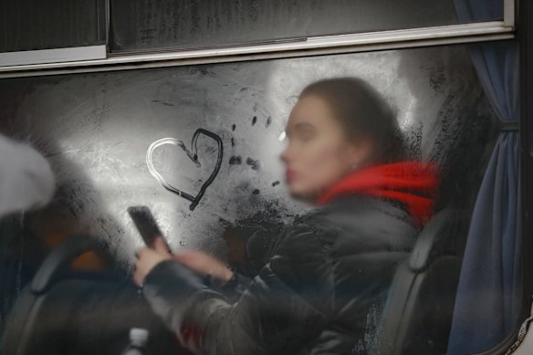 A woman travelling with others fleeing Ukraine, looks out of the window of a bus near the border crossing in Korczowa, Poland 