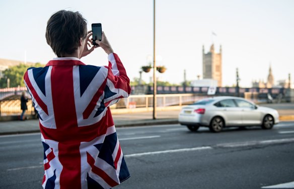 A vote LEAVE supporter takes a photo of Parliament from outside Vote Leave HQ, Westminster Tower in London, England.